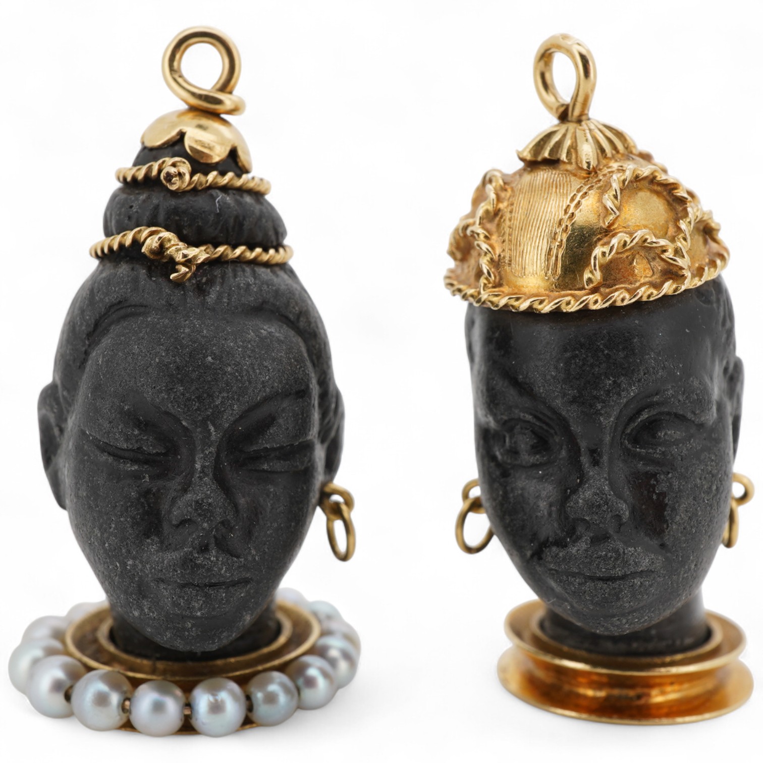 Two yellow metal mounted carved Blackamoor head charms, one with seed pearl set base, both overall approximately 30mm.